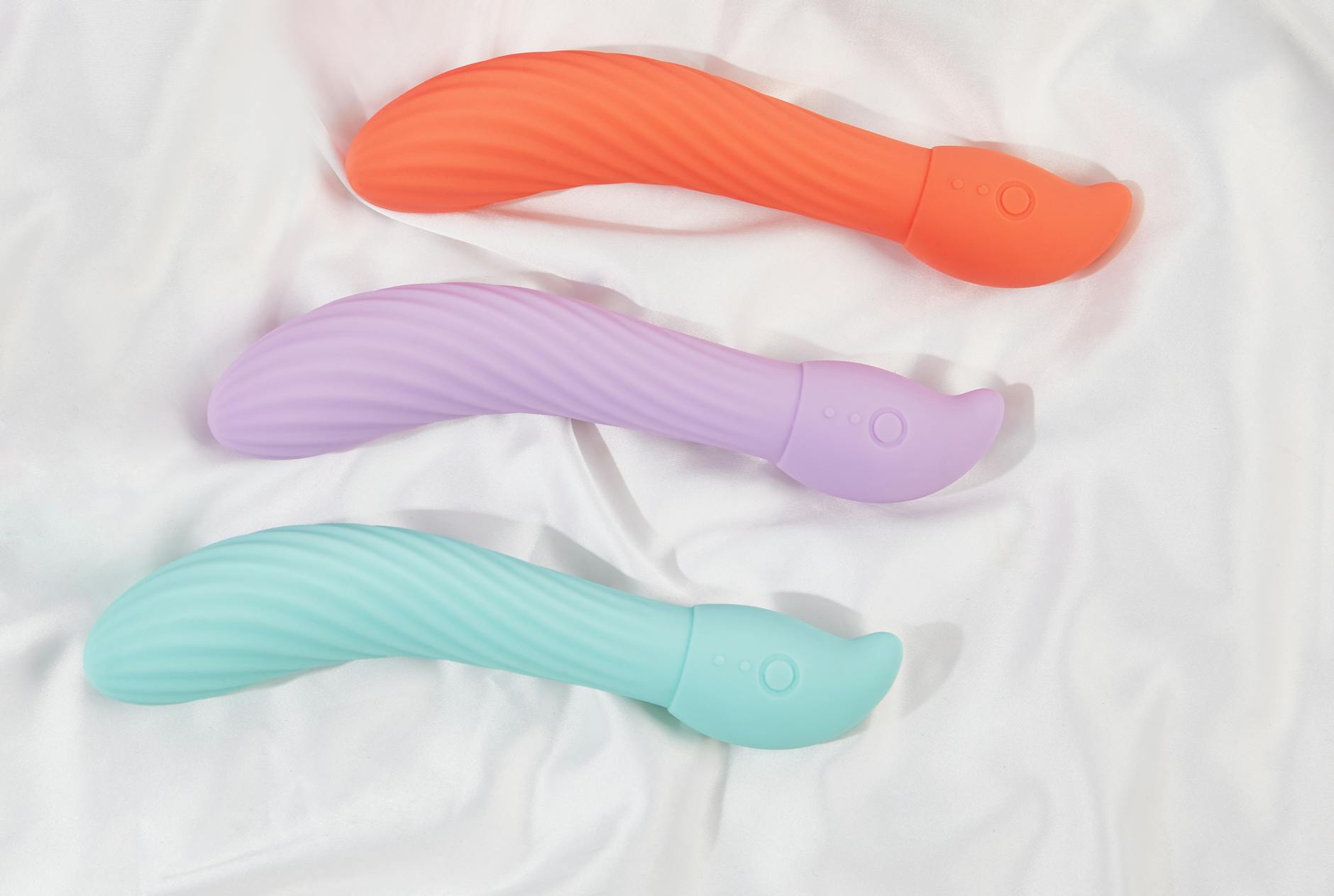 Blaue Silikon-Vibrator in Hand vor violettem Hintergrund, Symbol für Selbstliebe und Sexualität
