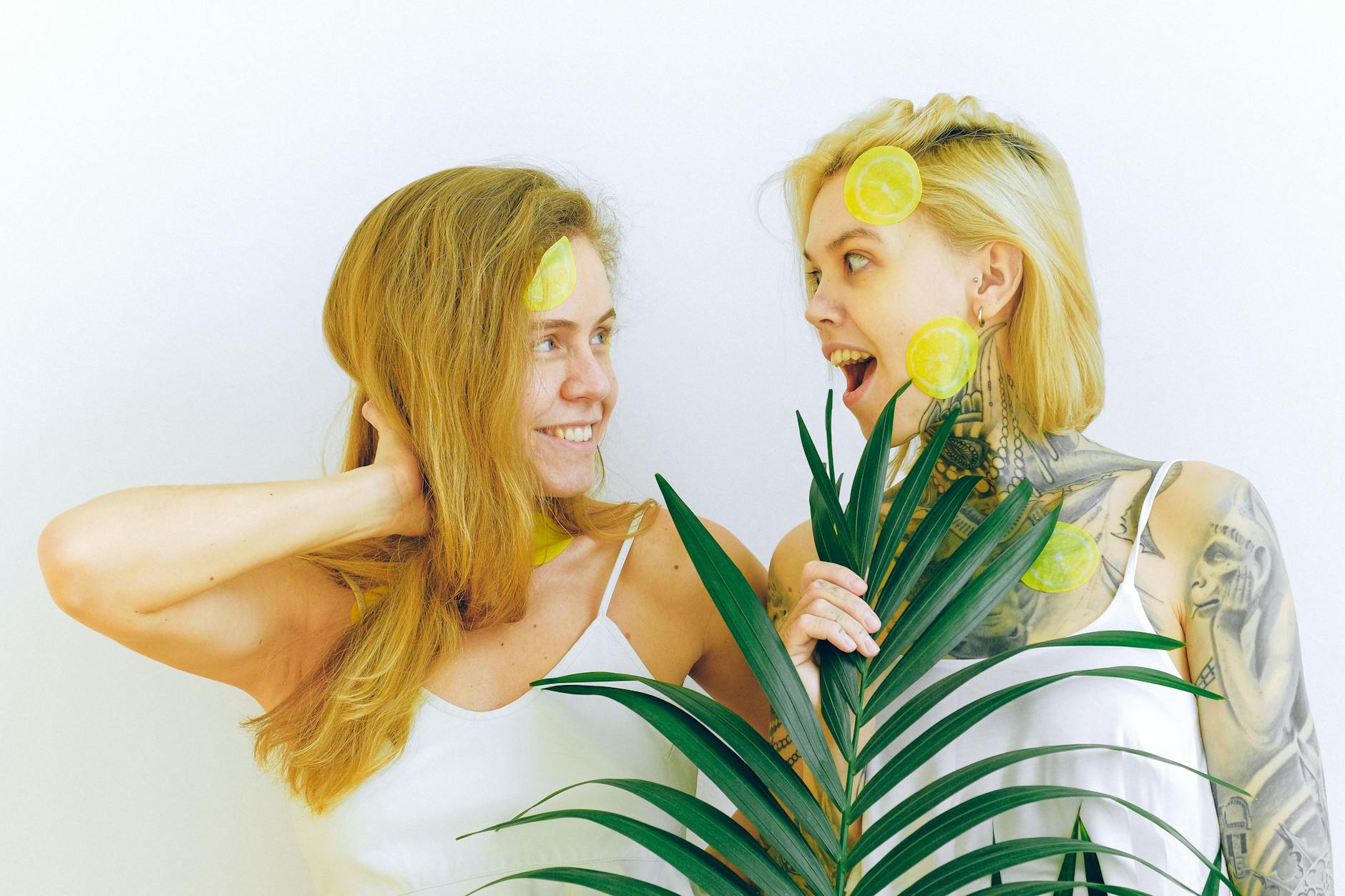 Two women smiling and expressing joy indoors with lemon-themed styling