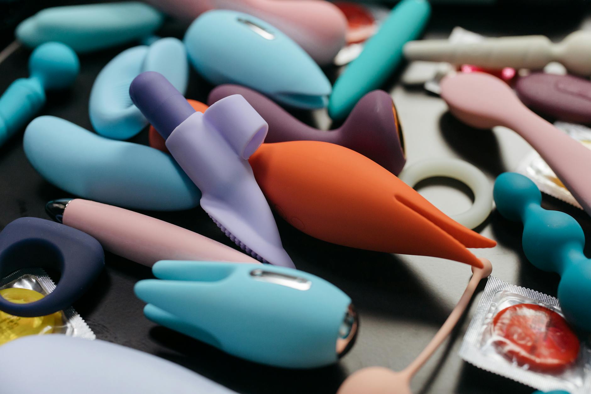 Array of colorful clitoral vibrators on a neutral background