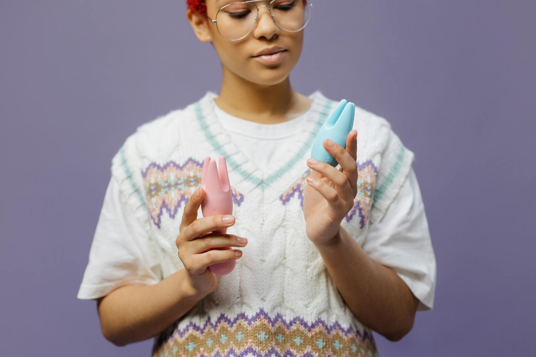 Woman holding colorful silicone vibrators in contemplative moment, exploring pleasure and sensation recovery.